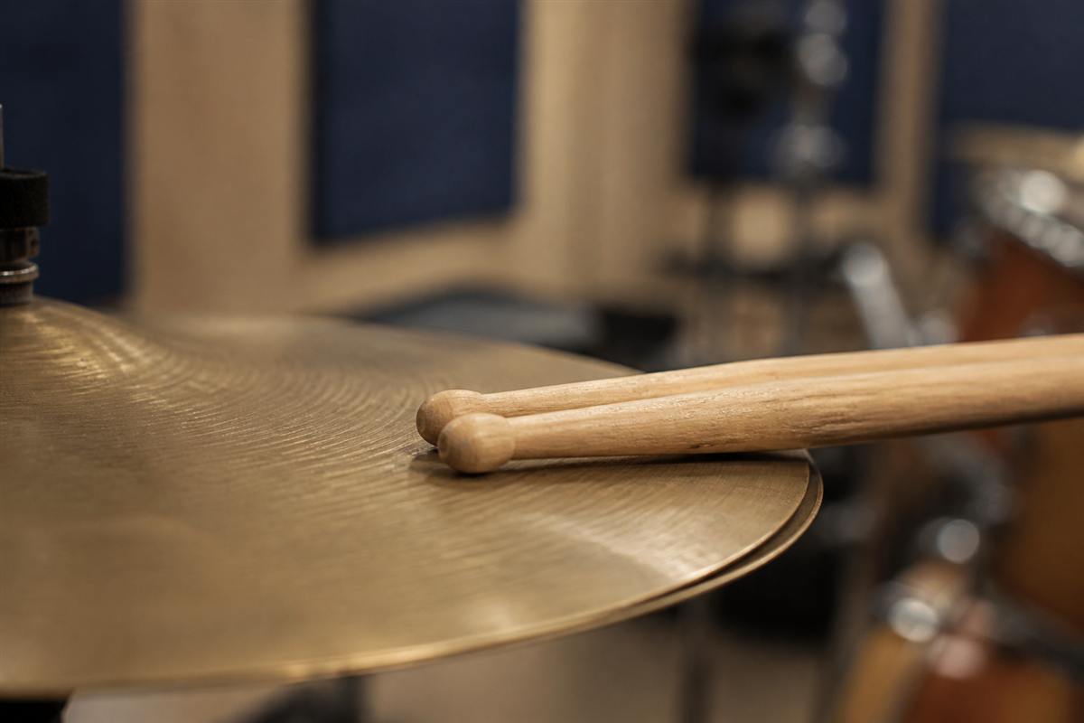 Oak drumsticks resting on a ride cymbal
